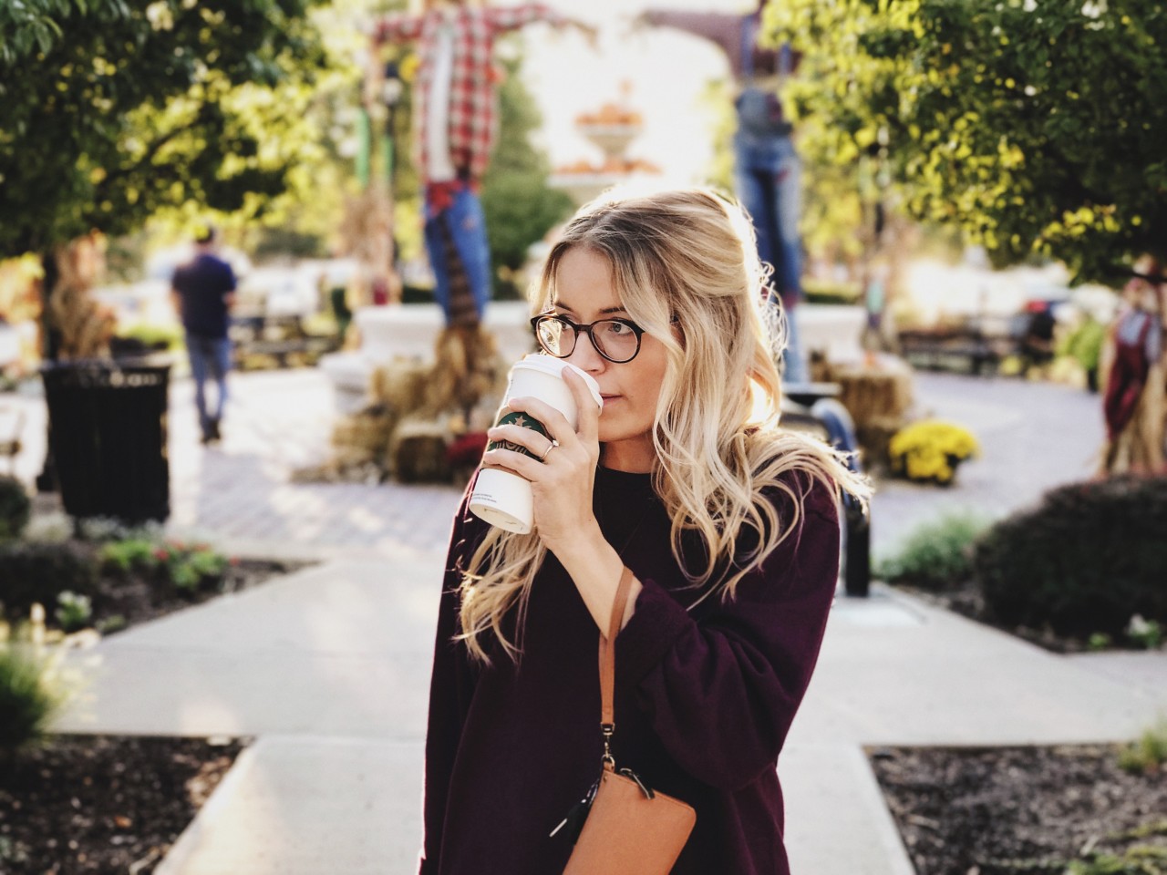 Kvinde drikker kaffe to-go i park 