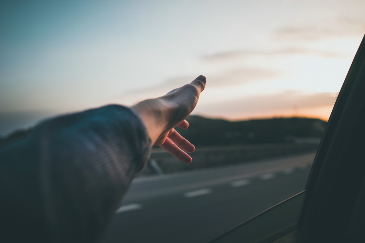main d'homme en dehors de la fenêtre d'une voiture