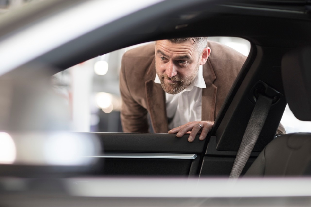 Homme qui regarde l'intérieur d'une voiture