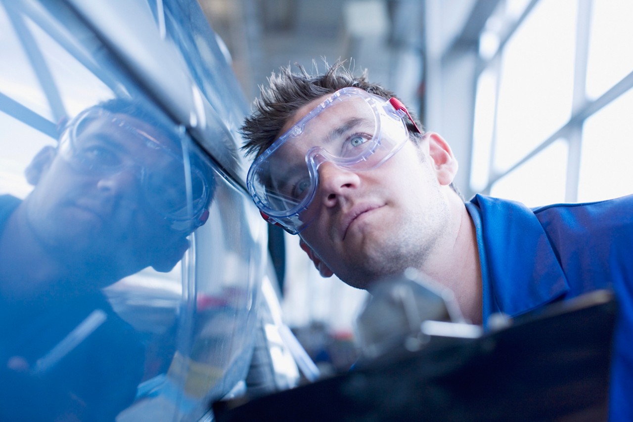 Homme qui inspecte une voiture