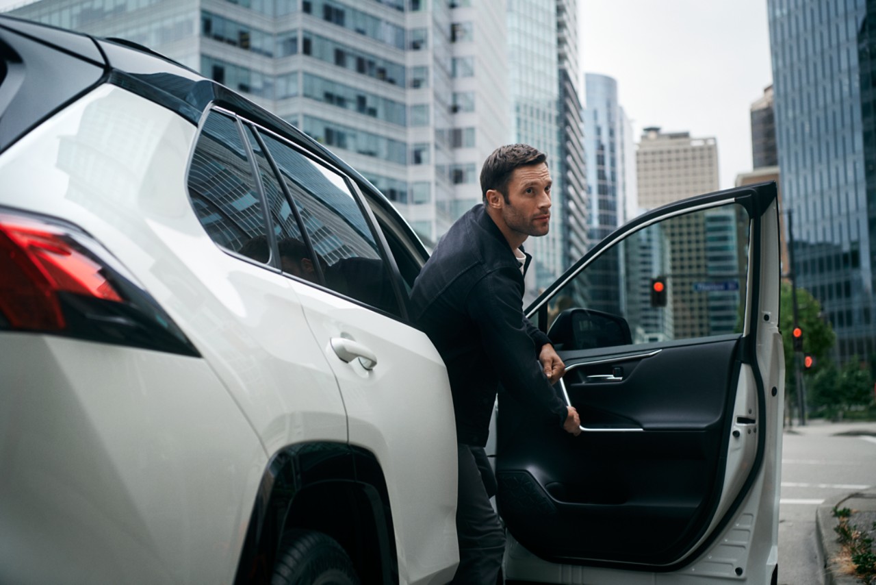 homme sortant d'une toyota en ville