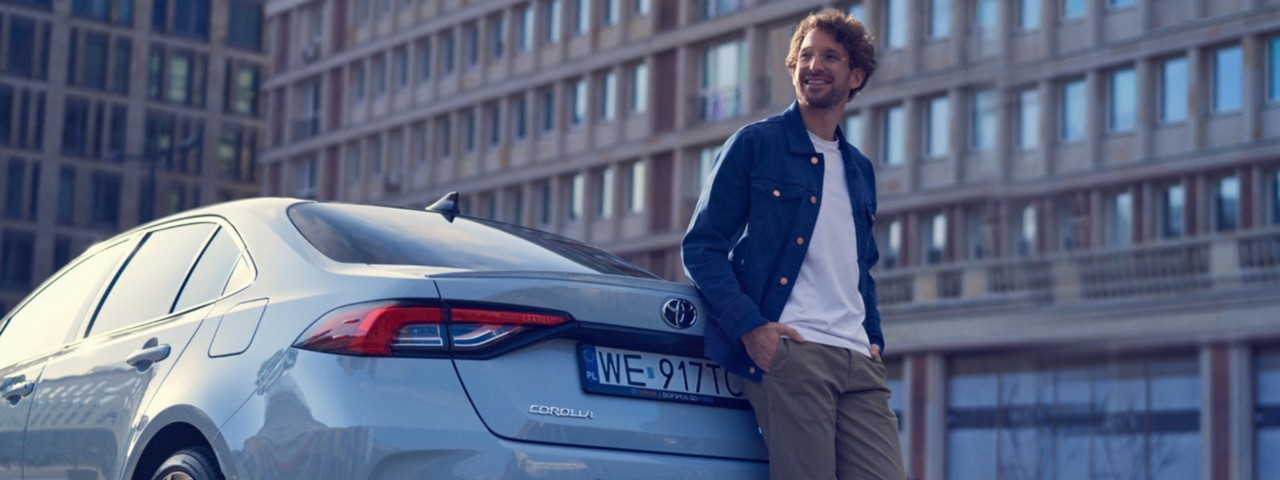 Toyota Corolla i mężczyzna obok samochodu